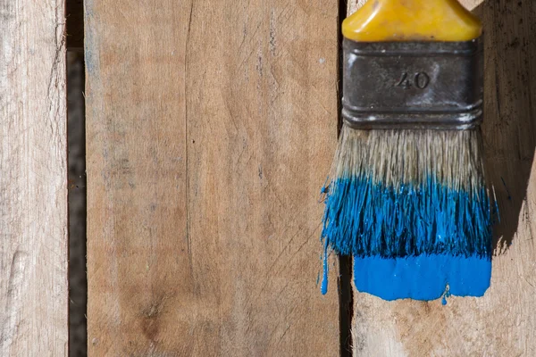 Closeup Of Pine Plank Being Painted In Blue Color Stock Photo