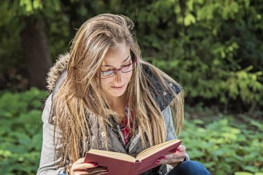 Güzel kız sonbahar Park kitap okuma