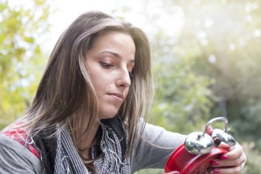 Genç kadın parkta kırmızı alarm saatli