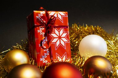 Altın arka planda dekoratif oyuncaklarla Noel hediyesi