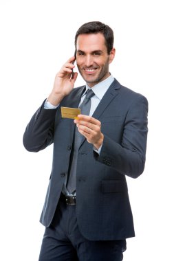Telefonda bir kredi kartı tutan gülümseyen işadamı portresi yarım uzunluk