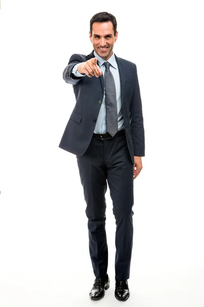 Полный портрет бизнесмена, улыбающегося и указывающего пальцем во время ходьбы — стоковое фото