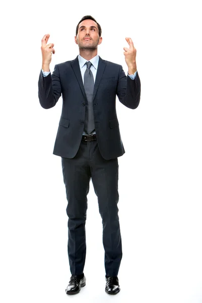 Full length portrait of a businessman looking above and keeping his fingers crossed — Stock Photo, Image