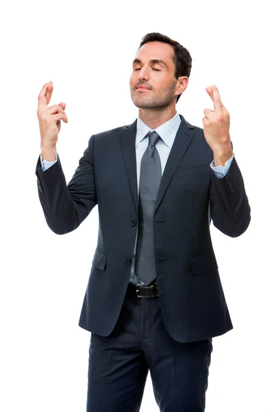 Half length portrait of a businessman with eyes closed and fingers crossed — Stock Photo, Image