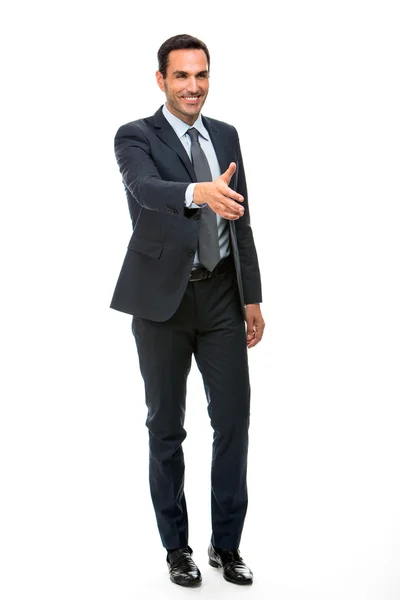 Полнометражный портрет бизнесмена, улыбающегося, поднимая руку для рукопожатия — стоковое фото
