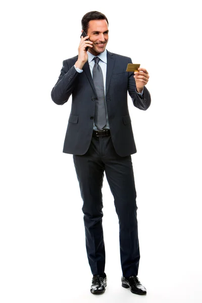 Retrato de comprimento total de homem de negócios sorrindo no telefone segurando um cartão de crédito — Fotografia de Stock