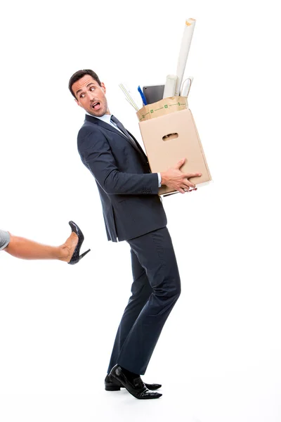 Retrato completo de um empresário carregando uma caixa de papelão e sendo chutado — Fotografia de Stock