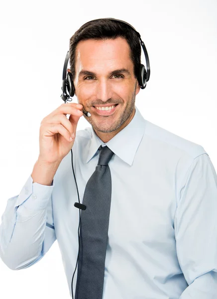 Retrato de um homem sorridente com fone de ouvido funcionando como operador de call center — Fotografia de Stock