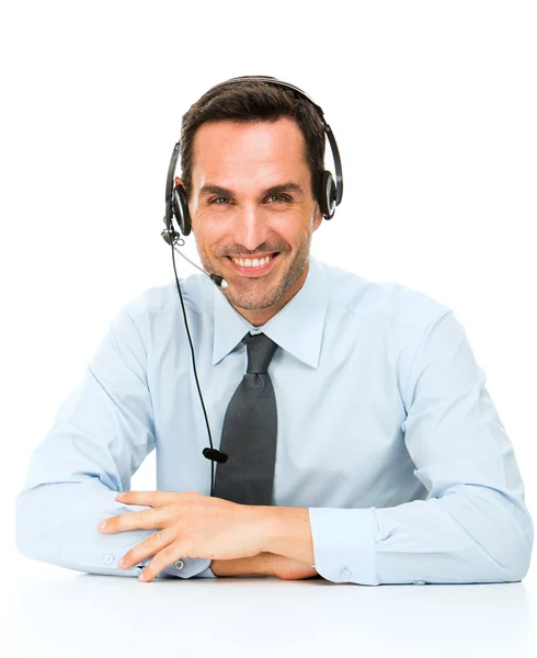 Portréja egy mosolygó ember hajol az asztalán fejhallgató — Stock Fotó