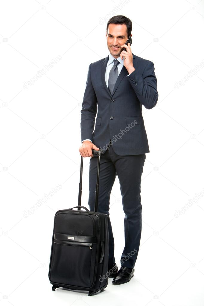 Full length portrait of a smiling businessman with trolley talking on the phone