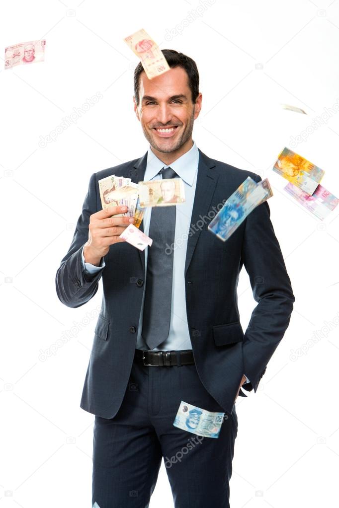 Half lenth portrait of a businessman smiling in falling money