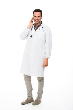 Tam uzunlukta portre os bir cep telefonu kullanırken stetoskop ile gülümseyen bir erkek doktor