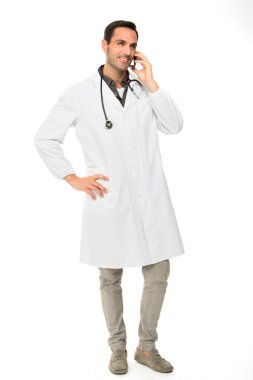 Tam uzunlukta portre os bir cep telefonu kullanırken stetoskop ile gülümseyen bir erkek doktor