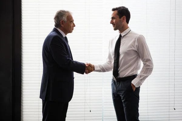 Portrait demi-longueur de deux hommes d'affaires debout et serrant la main — Photo