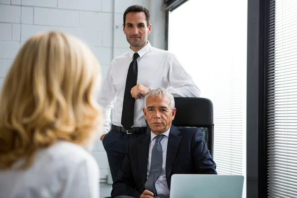 Drei Geschäftsleute bei einem Meeting im Büro mit Laptop auf dem Schreibtisch — Stockfoto