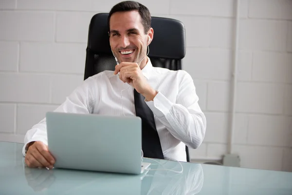 Businessman with earphones smiling — Stock Photo, Image