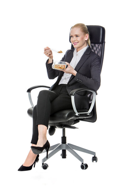Blonde businesswoman on a chair and having lunch