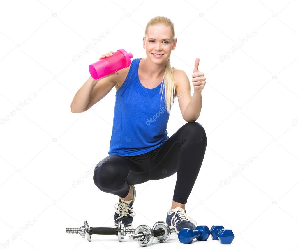 Blonde woman drinking after exercising with weights