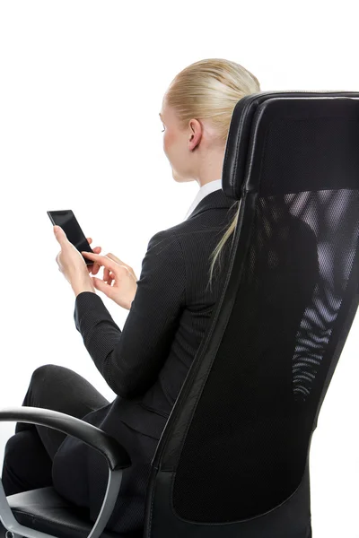 Empresária sentada em uma cadeira com telefone celular — Fotografia de Stock