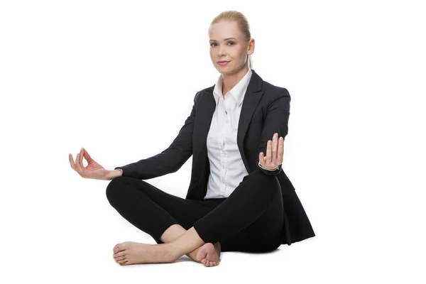 Mujer de negocios sentada en el suelo haciendo una posición de yoga — Foto de Stock