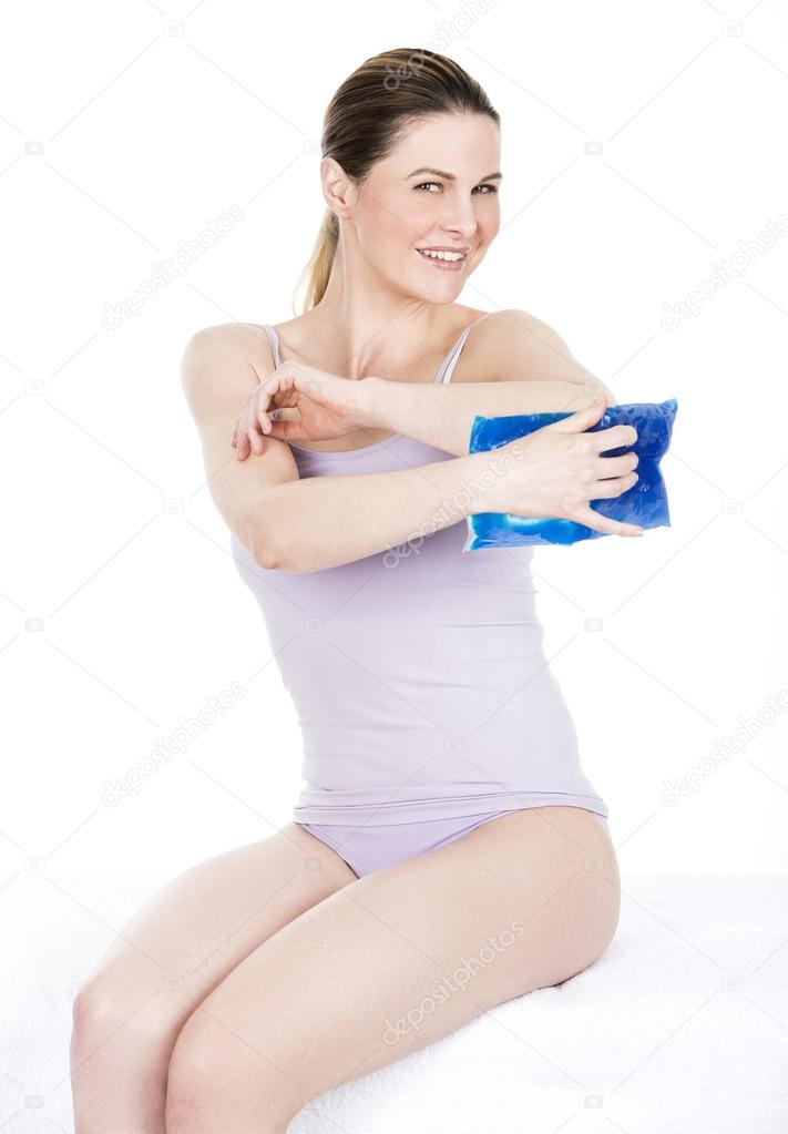 woman with cold hot pack on elbow for therapeutic relief
