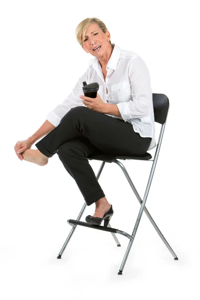 Mujer de negocios con los pies doloridos se sentó en una silla —  Fotos de Stock