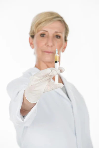 Middle age woman doctor with syringe Stock Photo