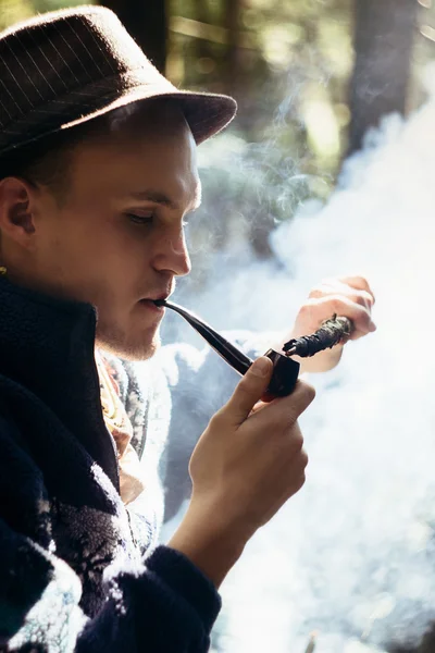 Стильный путешественник, курящий табачную трубку — стоковое фото