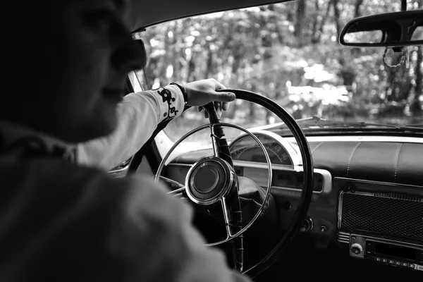Elegant groom driving retro car — Stock Photo, Image