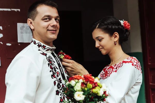 Mariée portant boutonnière sur le marié — Photo