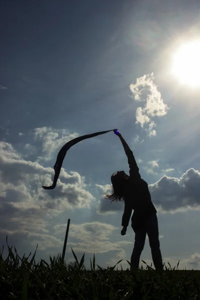 Силуэт девушки на ветреном поле — стоковое фото