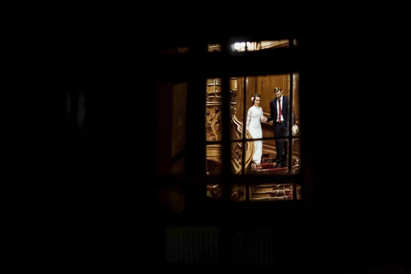 Vue à travers la fenêtre sur les mariés — Photo