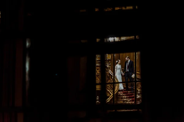 查看通过窗口上新娘和新郎 — 图库照片