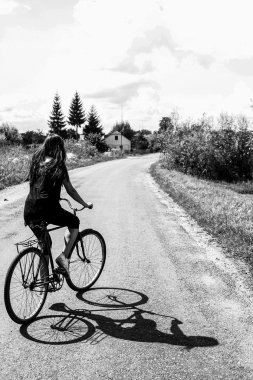Kız bir yolda bir bisiklet sürme 