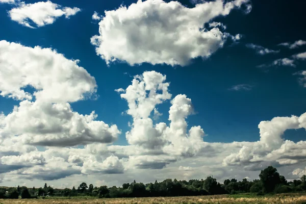 Úžasné mraky na modré obloze a do krajiny — Stock fotografie
