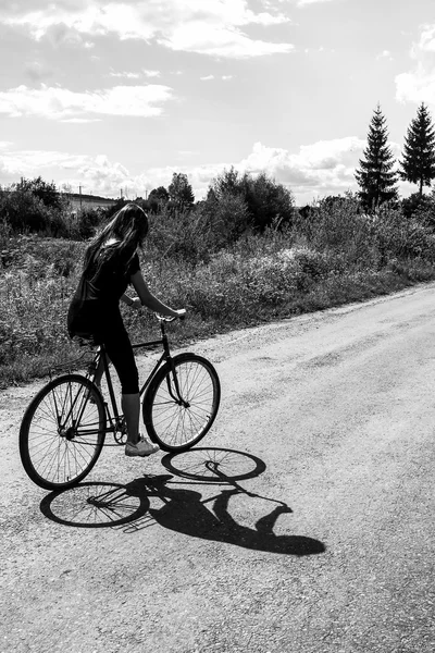 Menina andando de bicicleta em uma estrada — Fotografia de Stock