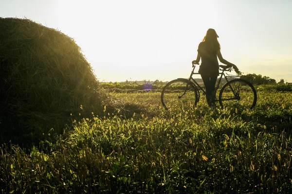 Silueta dívka sedí na kole — Stock fotografie