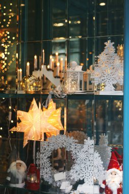 Modern vitrinlerde şık bir Noel yıldızı, çelenk, Noel Baba ve ağaçlar. Tatil alışverişi ve satışlar, Noel kutlaması sokak dekorasyonu. Mutlu Noeller.