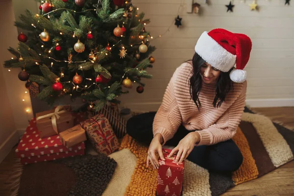 Счастливая Молодая Женщина Шляпе Санты Заворачивает Рождественский Подарок Современную Бумагу — стоковое фото