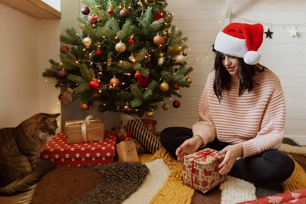 Happy Young Woman Santa Hat Wrapping Christmas Gift Her Cat — Stock Photo, Image