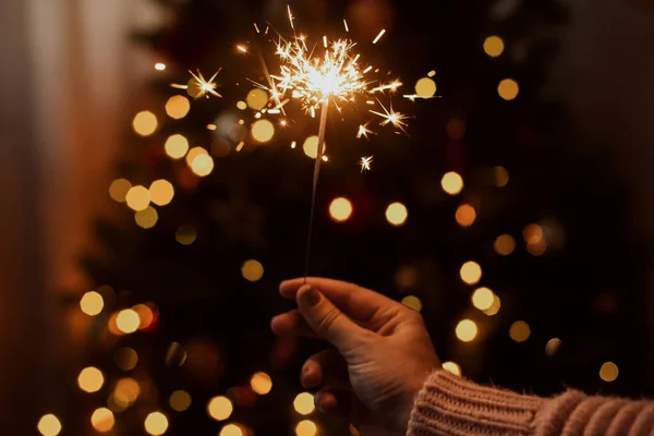 Hořící Jiskra Ruce Pozadí Vánočního Stromku Světly Tmavé Slavnostní Místnosti — Stock fotografie