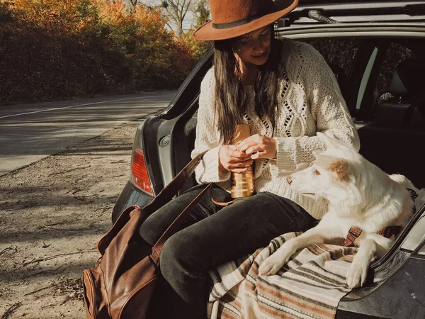 Стильная Молодая Женщина Сидящая Своей Белой Собакой Багажнике Автомобиля Фоне — стоковое фото