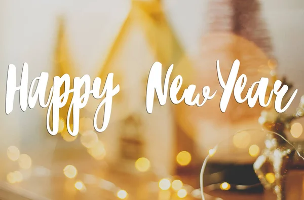 抽象的な休日の背景に手書きの幸せな新年のテキストは 黄金のお祝いの光の中でミニチュア妖精の村のぼんやりとした照明ボケ グリーティングカード現代の季節の挨拶 — ストック写真
