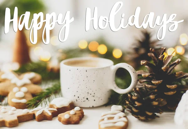 クリスマスのジンジャーブレッドクッキー コーヒー 松のコーンと暖かい照明に手書きの幸せな休日のテキスト グリーティングカード現代の季節の挨拶 — ストック写真
