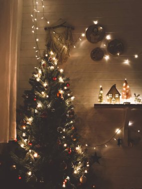 Noel ağacı, Noel arifesinde, modern dekore edilmiş karanlık odada kırmızı ve altın takılarla, şenlikli ışıklarda. Kış tatili için evi hazırlıyorum. Mutlu Noeller ve mutlu Noeller.!