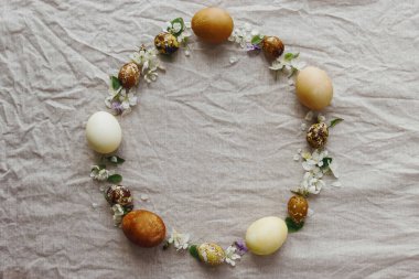 Mutlu Paskalyalar! Paskalya yumurtaları ve bahar çiçekleri kırsal çarşafların üzerinde, düzlük ve yazı için yer var. Doğal boya ve çiçeklerle süslenmiş estetik paskalya yumurtaları.