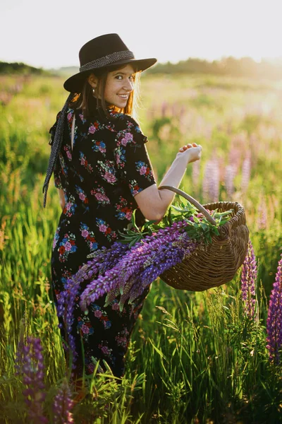 Güneşli Lup Tarlasında Elinde Çiçeklerle Gezen Mutlu Güzel Bir Kadın — Stok fotoğraf