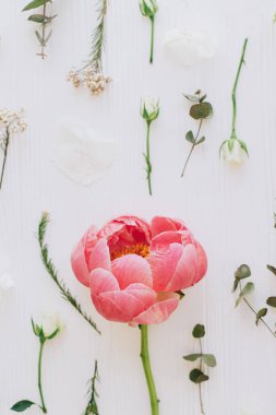 Merhaba bahar. Şık şakayık, güller, okaliptüs dalları ve beyaz ahşap düz yerde çiçek kompozisyonu, modern çiçek deseni. Anneler Günü ve kadınlar günü konsepti kutlu olsun.