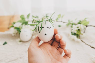 Paskalya yumurtası, çiçekli çelenk içinde uyuyan yüzü yumuşak ışıkta doğal yumurta ve keten kumaşın üzerinde taç yaprakları. Mutlu Paskalyalar ve Paskalya Avları konsepti! Metin için boşluk