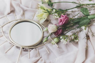 Yumuşak kumaş üzerinde güzel bir buket boho aynası. Bahar estetiği. Anneler Günün kutlu olsun. Nazik bir görüntü. Manuka, alstromerya ve Eustoma çiçekli göz şeklindeki ayna.